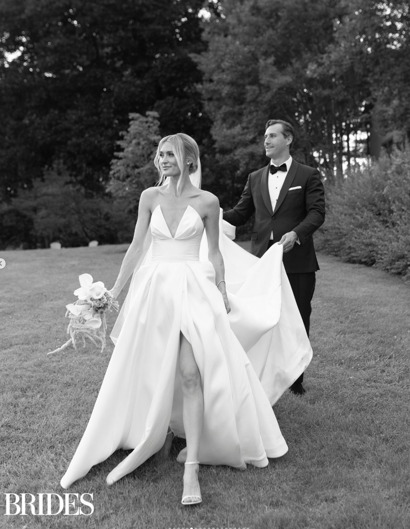 Bride and groom walking hand in hand through a golden-hour meadow